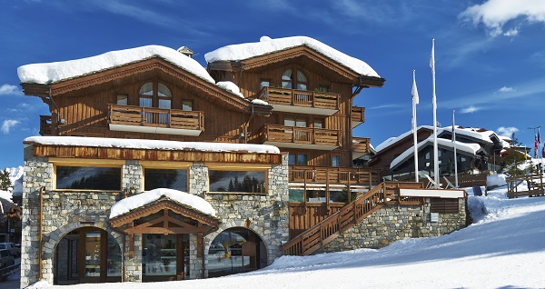 Chalet en bois dans un paysage de montagne enneigée
